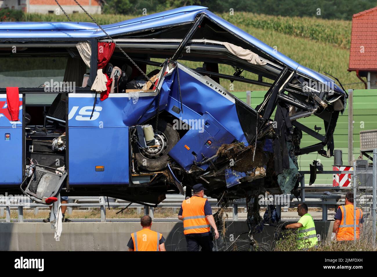 Rescuers work as a crane removes the bus with Polish licence plates that slipped off a road, from the scene near Varazdin, northwestern Croatia, August 6, 2022. REUTERS/Antonio Bronic Stock Photo