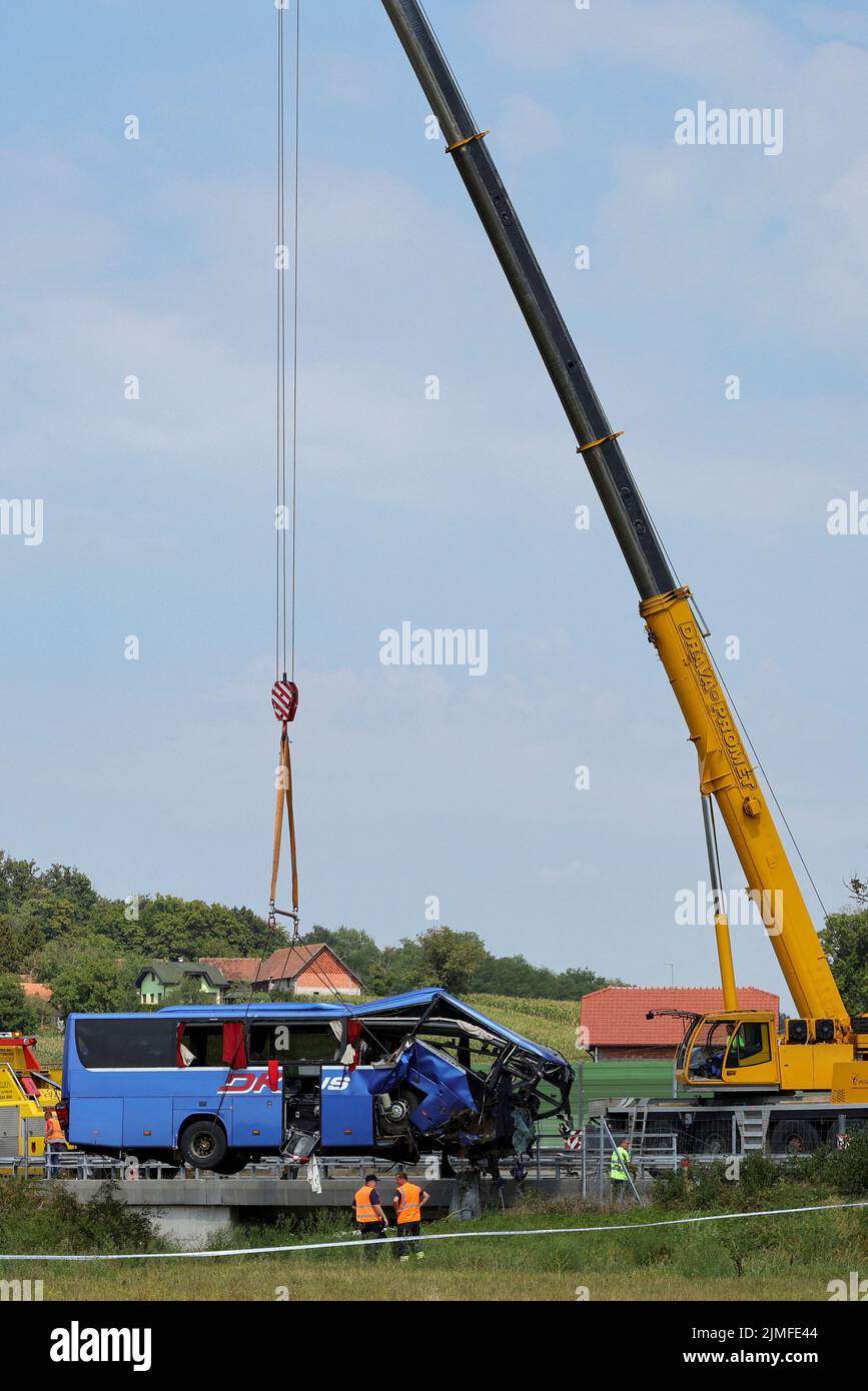A crane removes the bus with Polish licence plates that slipped off a road, from the scene near Varazdin, northwestern Croatia, August 6, 2022. REUTERS/Antonio Bronic Stock Photo
