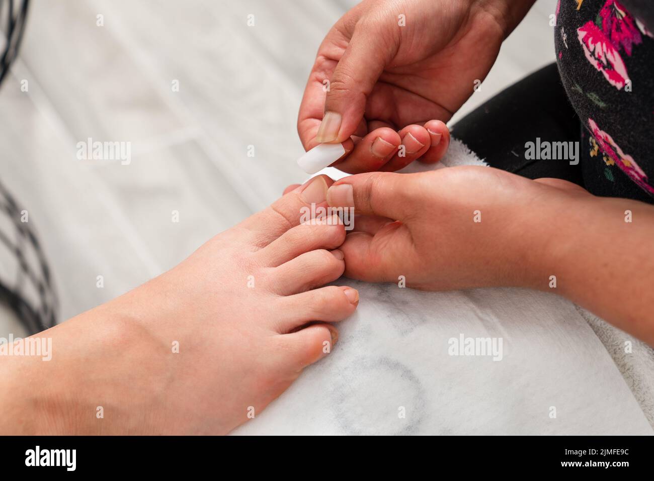 Close up photo of toenail filing. Woman get professional pedicure treatment in beauty salon. Beauty and cosmetic concept. High quality photo Stock Photo