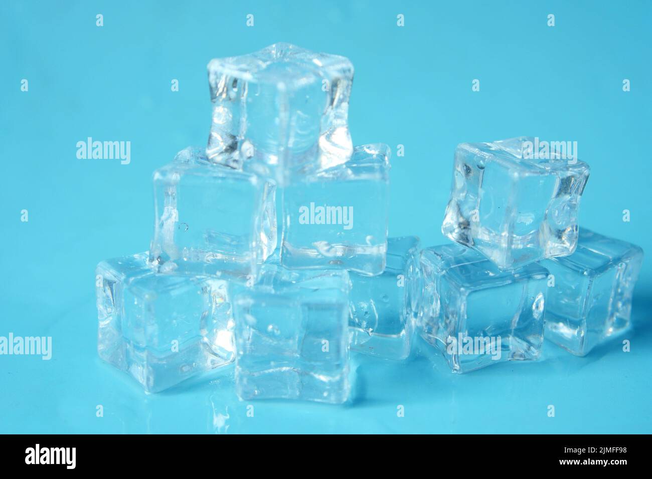 close up of many ice cubes on blue background  Stock Photo