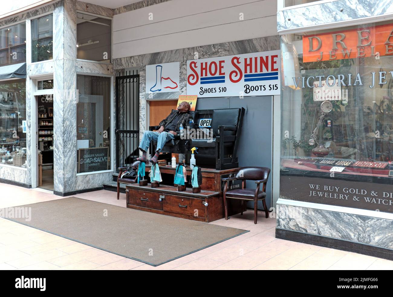 An older African-American shoe shine man takes a rest in the century-old 5th Street Arcade, an historic indoor shopping arcade in Cleveland, Ohio, USA Stock Photo