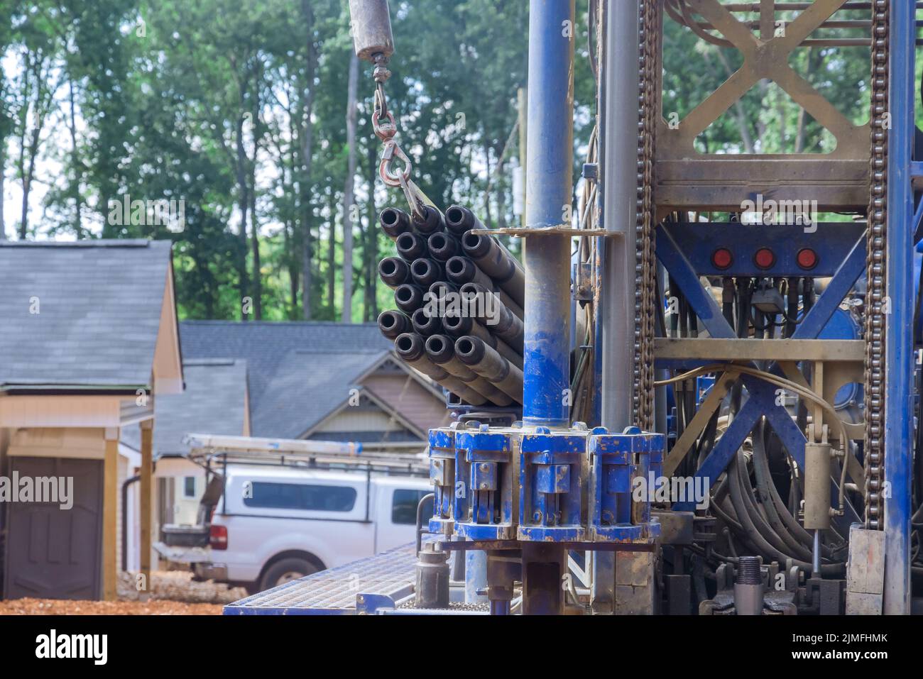 Water extraction from a portable hydraulic well drilling rig located on a land plot owned by the owner Stock Photo