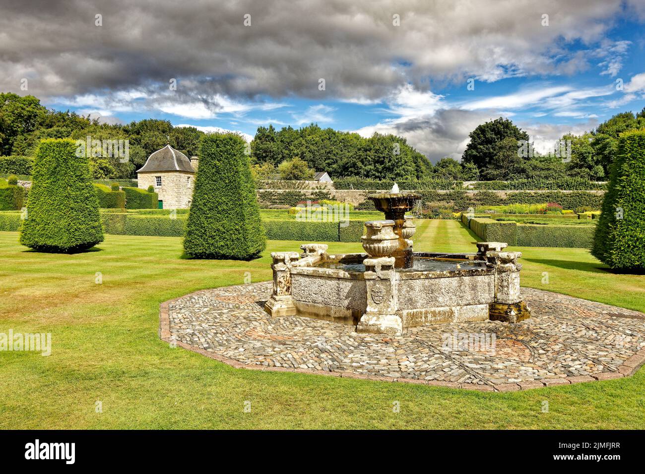 PITMEDDEN GARDEN ABERDEENSHIRE SCOTLAND IN SUMMER FOUNTAIN IN THE LOWER GARDEN AND A TWIN OGEE ROOFED PAVILION Stock Photo