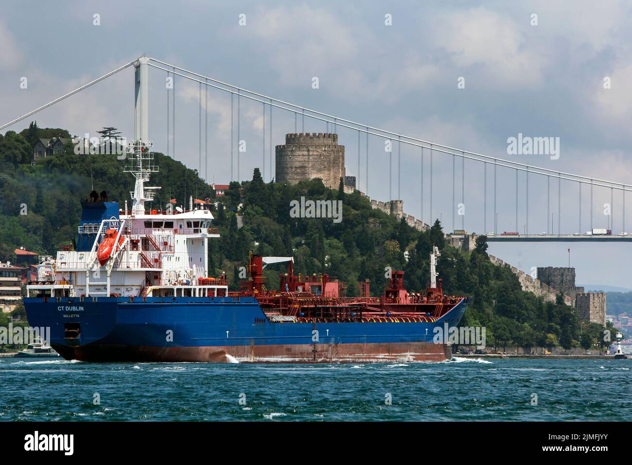 An ocean liner sails along the Bosphorus Strait towards the Fatih Sultan Mehmet Bridge at Istanbul in Turkey. Stock Photo