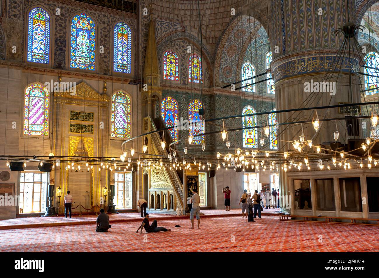 A view inside the Blue Mosque or Sultan Ahmet Camii at Istanbul in Turkey showing the minbar and stained glass windows. Stock Photo