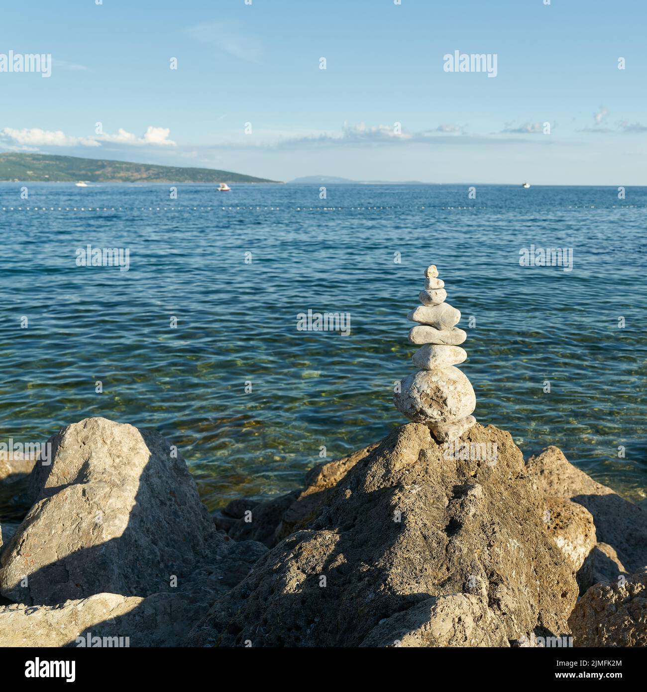 Piled up stones and beautiful view of the Adriatic Sea near the town of Krk in Croatia Stock Photo