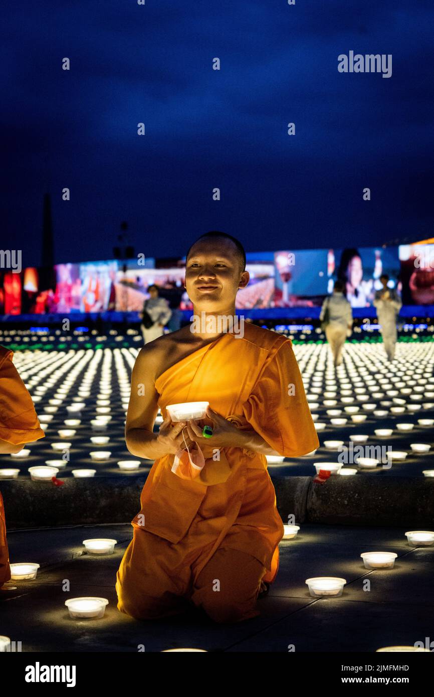 Pathum Thani, Thailand. 06th Aug, 2022. A monk holds an LED torch while praying during a mass meditation ceremony to promote world peace at Wat Phra Dhammakaya. Wat Phra Dhammakaya commemorates the World Fellowship of Buddhist Youth (WFBY) 'World Meditation Day' by meditating together for peace and lighting 100,000 LEDs at their temple in Pathum Thani. Credit: SOPA Images Limited/Alamy Live News Stock Photo