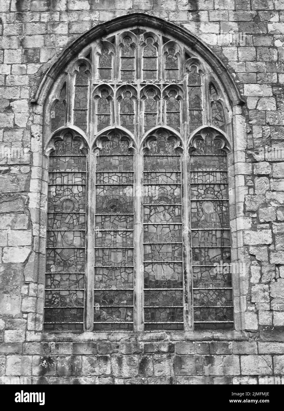 Old window on the historic medieval cartmel priory in cumbria now the parish church of st micheal and mary Stock Photo