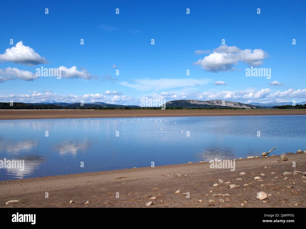 The river kent in cumbria with with lake district hills in the distance and clouds reflected in the water Stock Photo