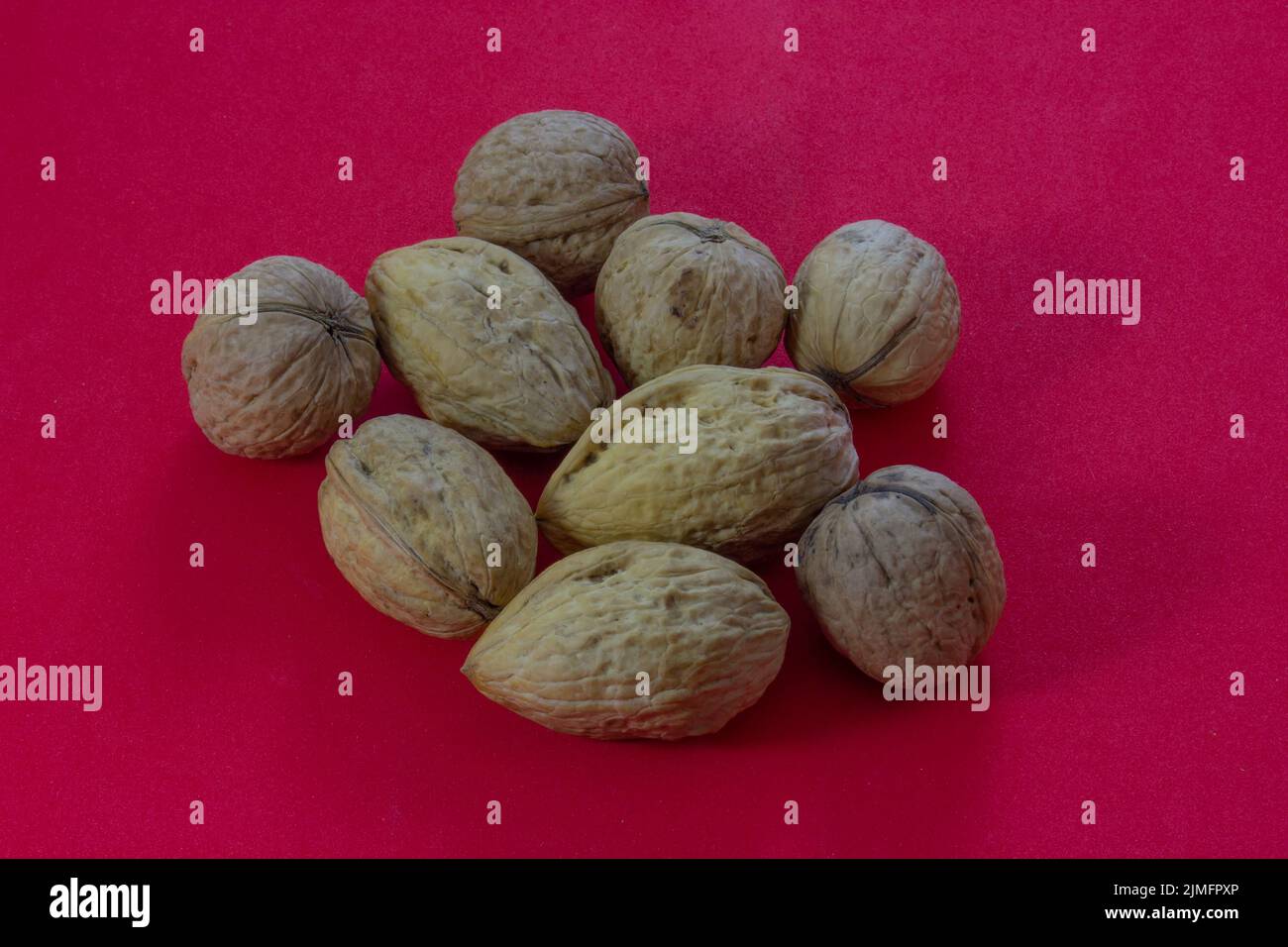 Walnuts on a red background. Stock Photo
