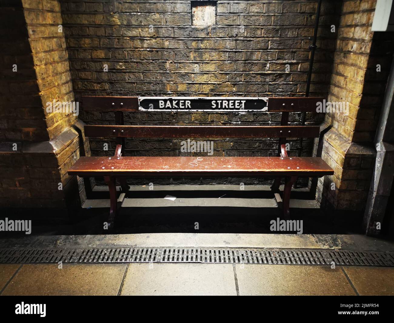 Old and vintage bench in Baker Street underground station, in a dark and mysterious atmosphere, London, England, United Kingdom. Stock Photo
