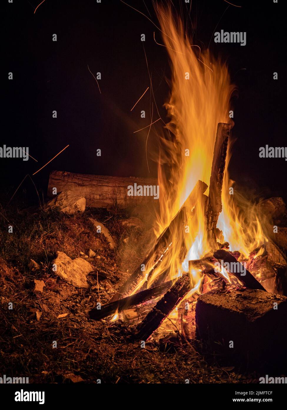 logs burning in camp fire in darkness Stock Photo