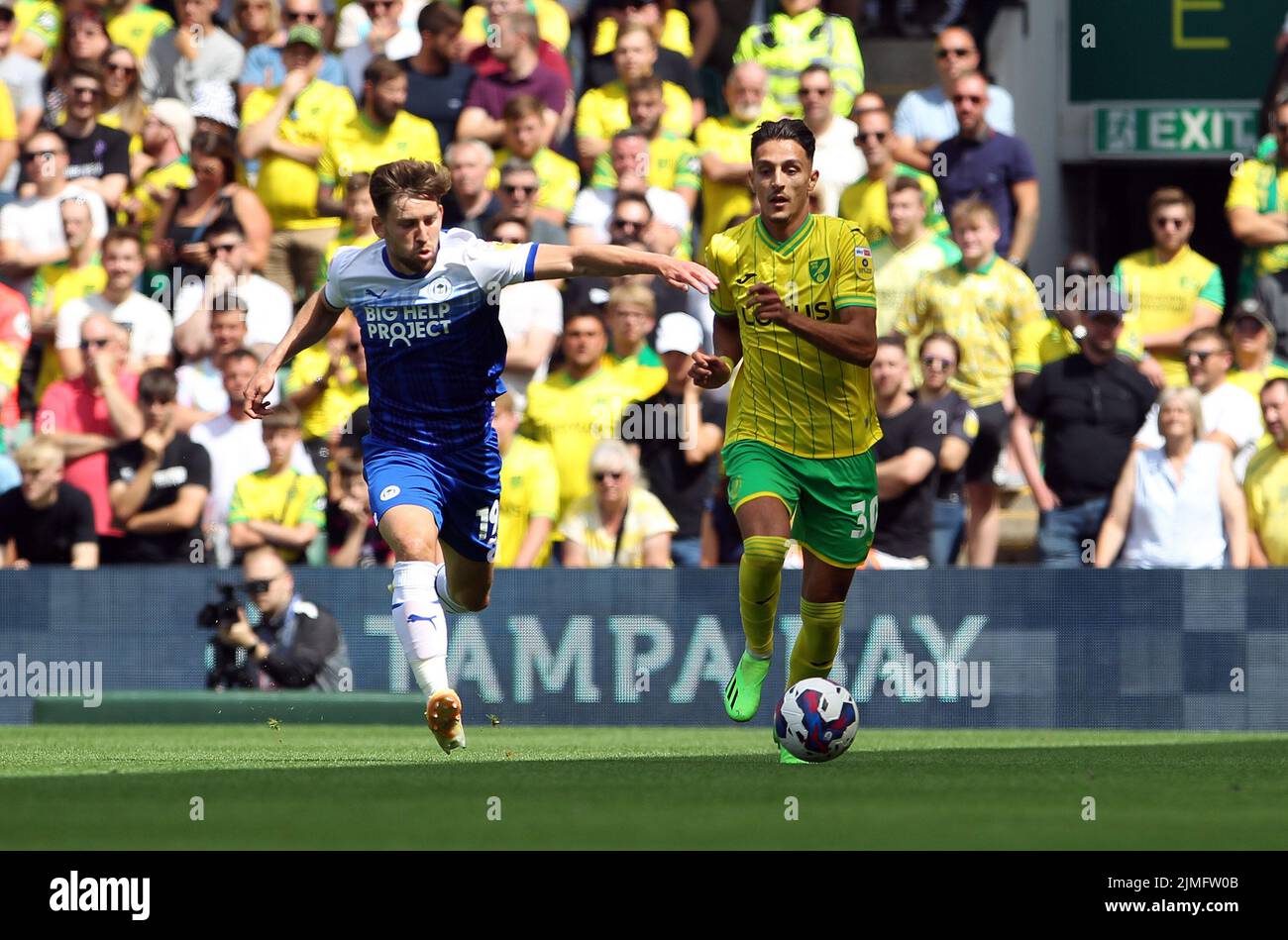 Norwich, UK. 06th Aug, 2022. Dimitris Giannoulis of Norwich City runs with the ball and is chased by Callum Lang of Wigan Athletic during the Sky Bet Championship match between Norwich City and Wigan Athletic at Carrow Road on August 6th 2022 in Norwich, England. (Photo by Mick Kearns/phcimages.com) Credit: PHC Images/Alamy Live News Stock Photo
