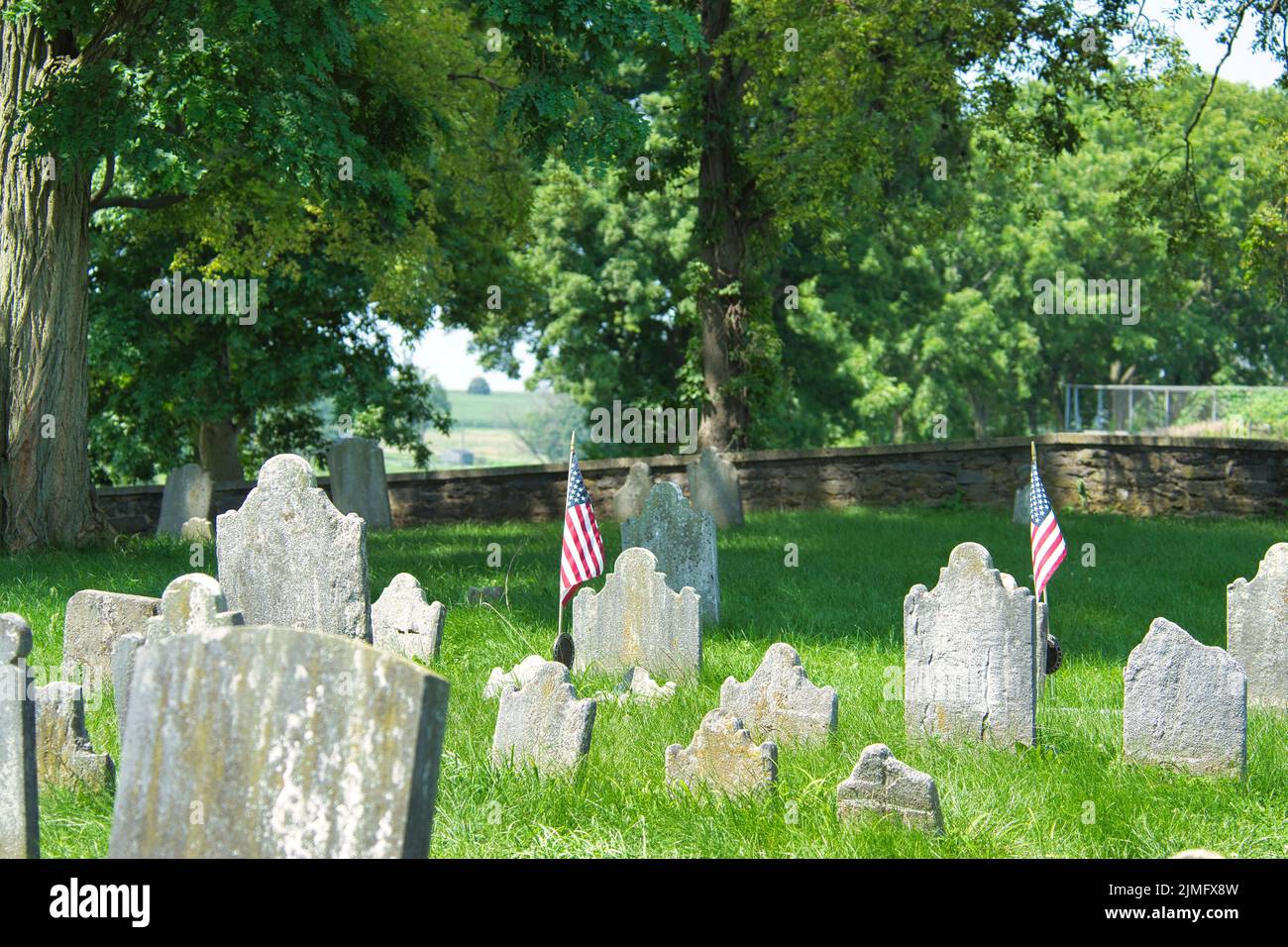Old Cemetery Sits in the Woods With Head Stones Falling Stock Photo