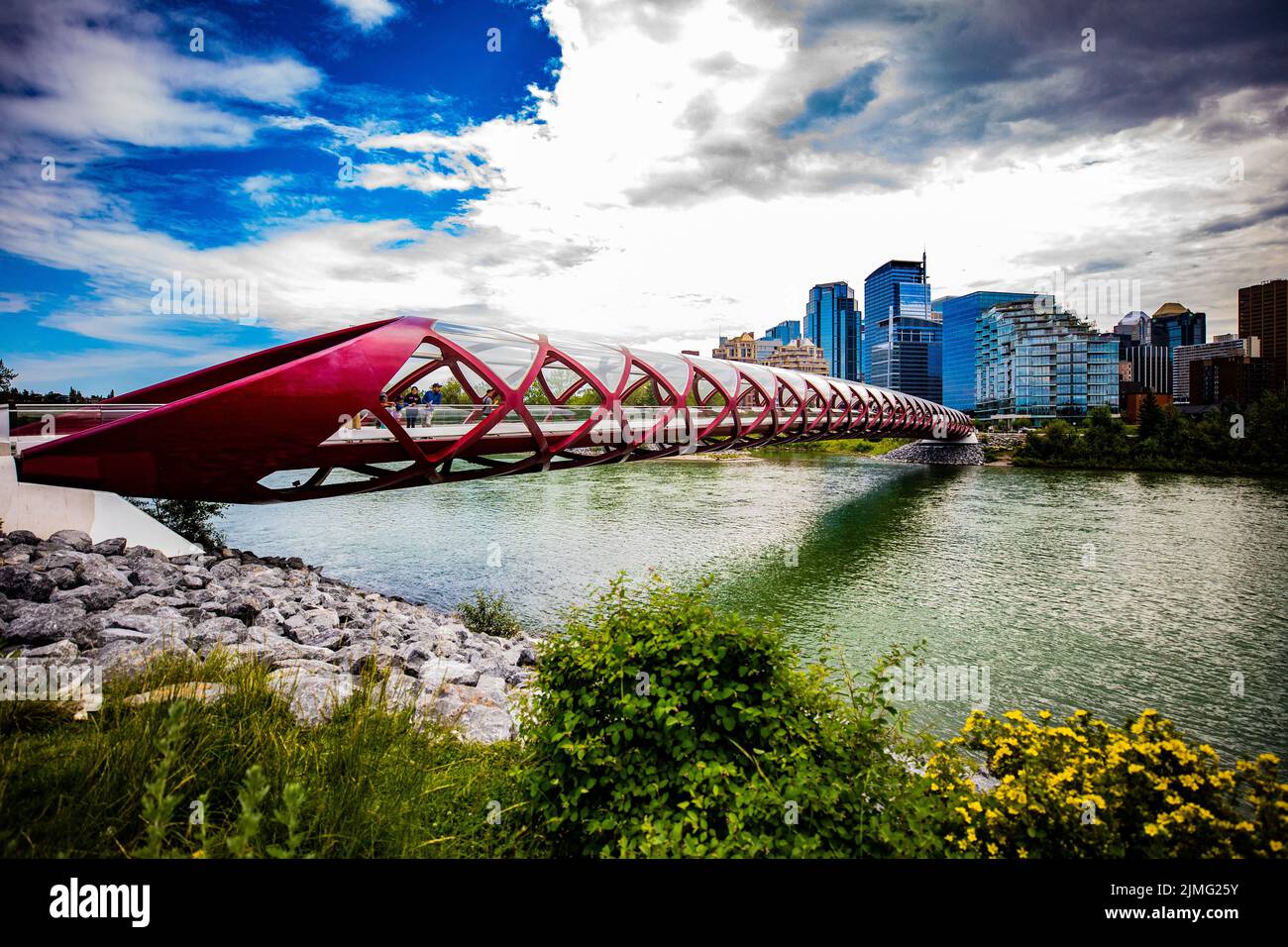 A vibrant cityscape of the red Peace Bridge over Bow River in Calgary, Alberta, Canada Stock Photo
