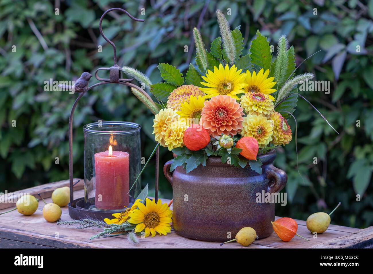 bouquet of orange and yellow dahlias and sunflowers in old clay pot Stock Photo