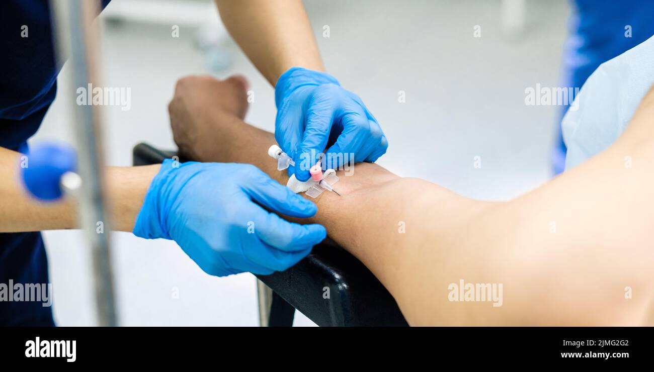 Placement of a catheter in the patient's arm Stock Photo