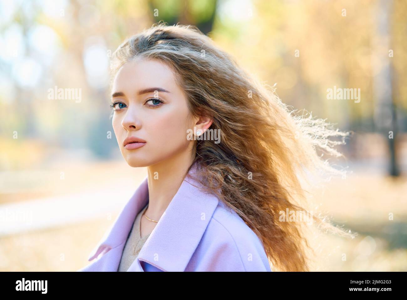 Portrait of stylish pretty woman posing outdoors in autumn park ...