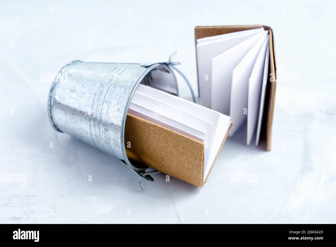 Books in a small trash bucket isolated on a concrete background ...