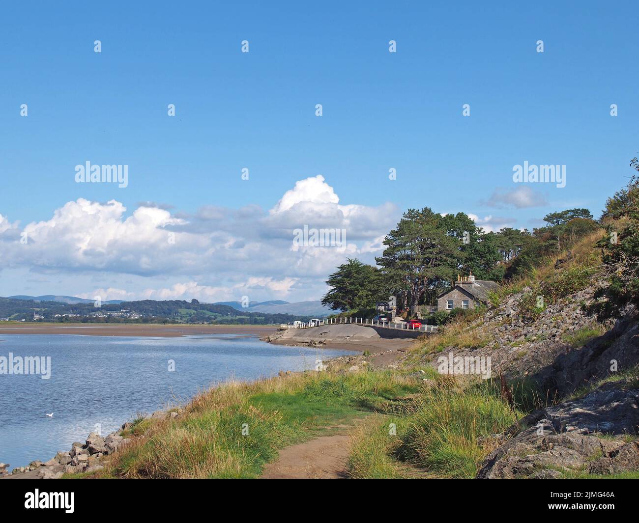 View of the houses along the coast road in arnside in cumbria with surrounding lake district hills in summer Stock Photo