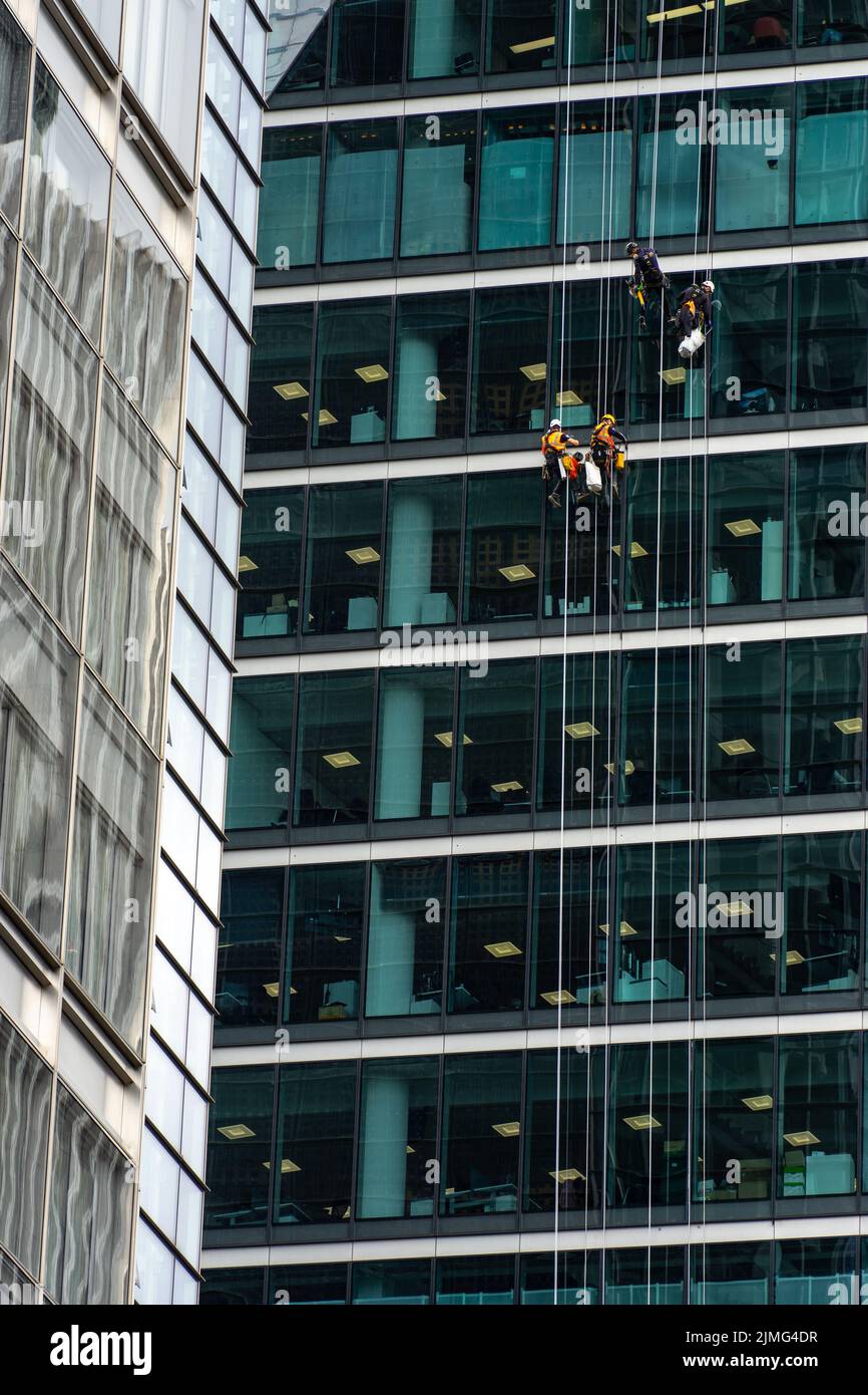 London, UK Jun 09 2022 Four industrial alpinists cleaning large