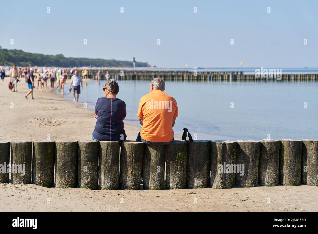 Couple on a breakwater on the beach of Kolobrzeg on the Baltic Sea in Poland Stock Photo