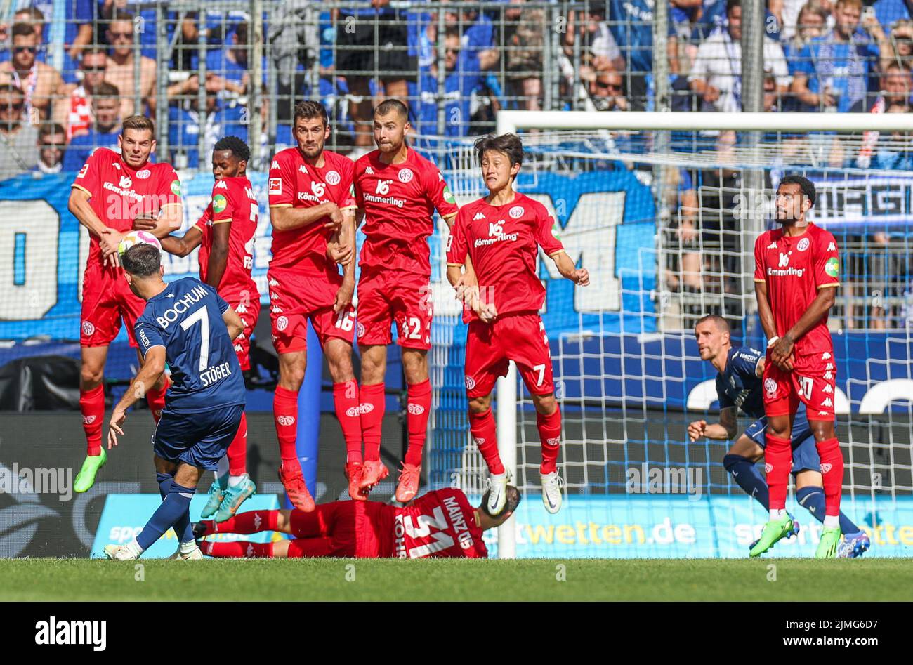 06 August 2022, North Rhine-Westphalia, Bochum: Soccer: Bundesliga, VfL Bochum - FSV Mainz 05, Matchday 1, Vonovia Ruhrstadion.  Kevin Stöger of VfL Bochum shoots a free kick into the wall of the Mainz players. Photo: Tim Rehbein/dpa - IMPORTANT NOTE: In accordance with the requirements of the DFL Deutsche Fußball Liga and the DFB Deutscher Fußball-Bund, it is prohibited to use or have used photographs taken in the stadium and/or of the match in the form of sequence pictures and/or video-like photo series. Stock Photo