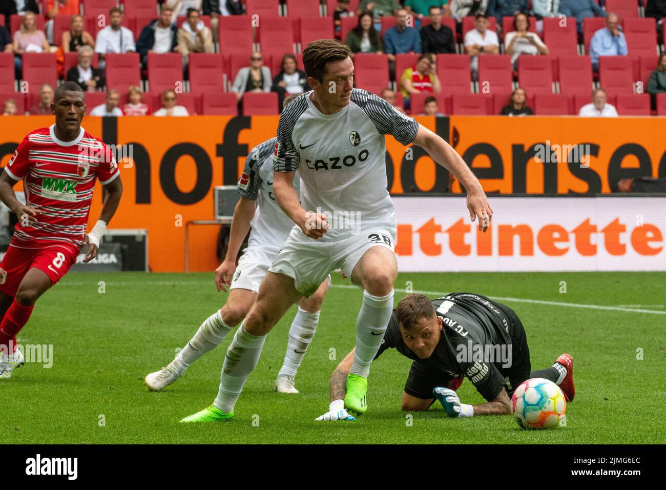 06 August 2022, Bavaria, Augsburg: Soccer, Bundesliga, FC Augsburg - SC Freiburg, Matchday 1, WWK-Arena. Augsburg goalkeeper Rafal Gikiewicz (r) can only look behind Freiburg's Michael Gregoritsch. Photo: Stefan Puchner/dpa - IMPORTANT NOTE: In accordance with the requirements of the DFL Deutsche Fußball Liga and the DFB Deutscher Fußball-Bund, it is prohibited to use or have used photographs taken in the stadium and/or of the match in the form of sequence pictures and/or video-like photo series. Stock Photo