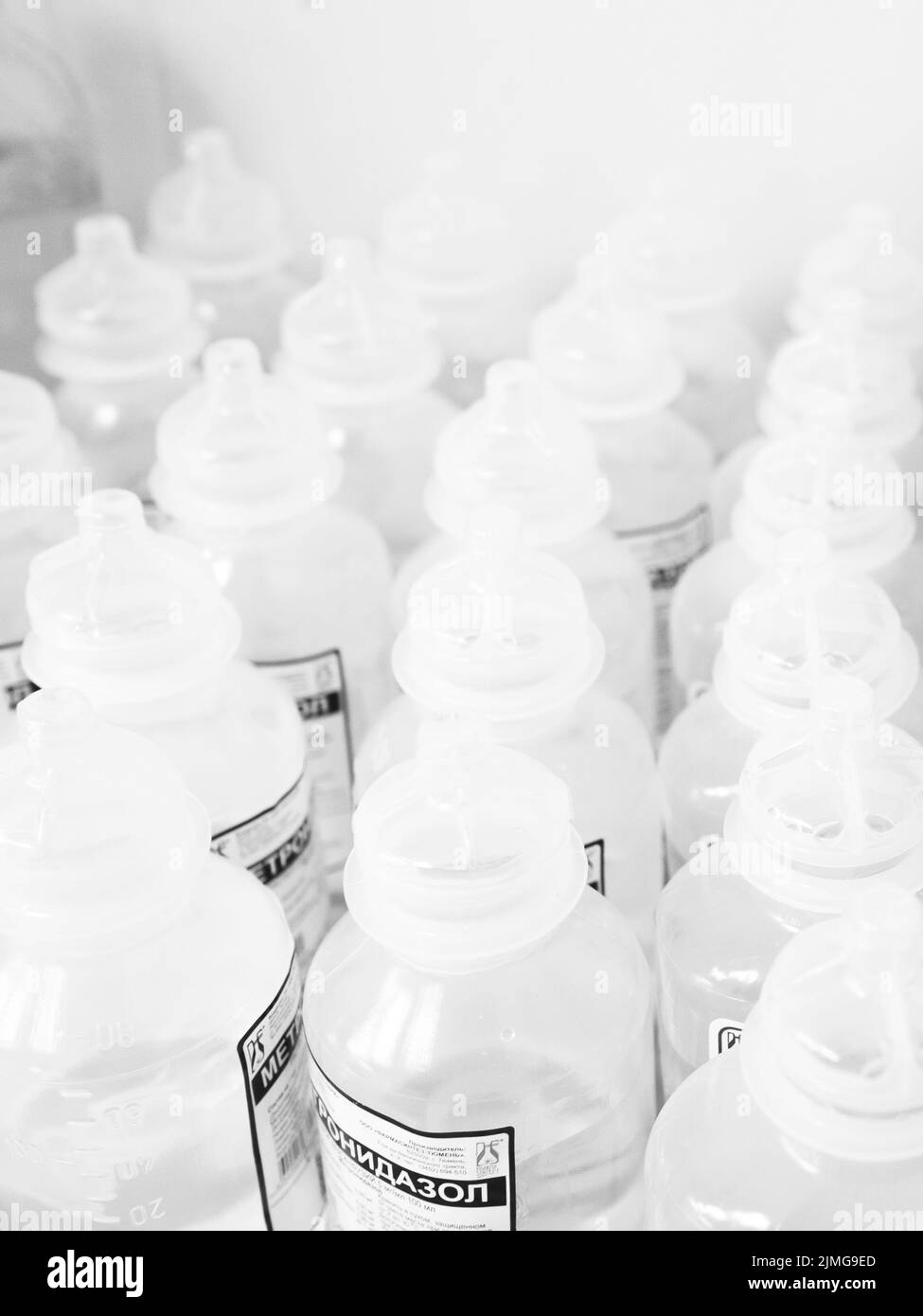 Many of identical white plastic medicine bottles, with focus on one of