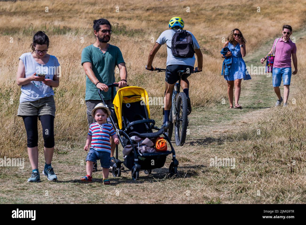 London, UK. 6th Aug, 2022. People walk and have picnics in the yellow scorched grass of Parliament Hill - Hot weather continues the drought conditions on Hampstead Heath. Credit: Guy Bell/Alamy Live News Stock Photo