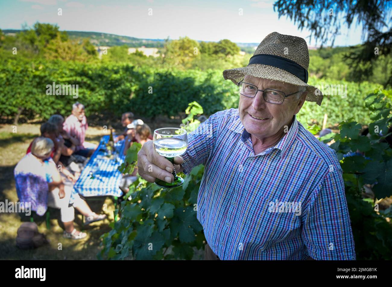 06 August 2022, Saxony-Anhalt, Naumburg: Vintner Rudolf Frölich has invited to a wine tasting on his vineyard in Roßbach.  Wineries and winegrowers' stations of the Saale-Unstrut wine region and the Mansfeld Lakes Wine Route around Höhnstedt show how and where their wines are made. Photo: Heiko Rebsch/dpa Stock Photo