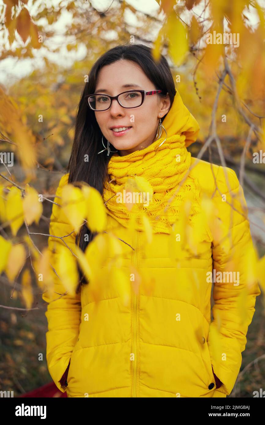 Beautiful woman in a yellow jacket and scarf on an autumn forest background Stock Photo Alamy