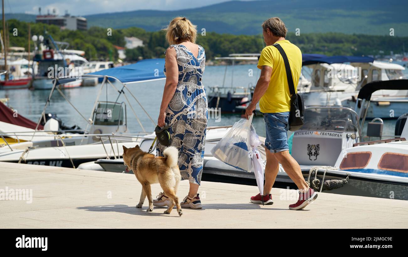 Holidaymakers with dog in the port of the town of Krk on the Adriatic Sea in Croatia Stock Photo