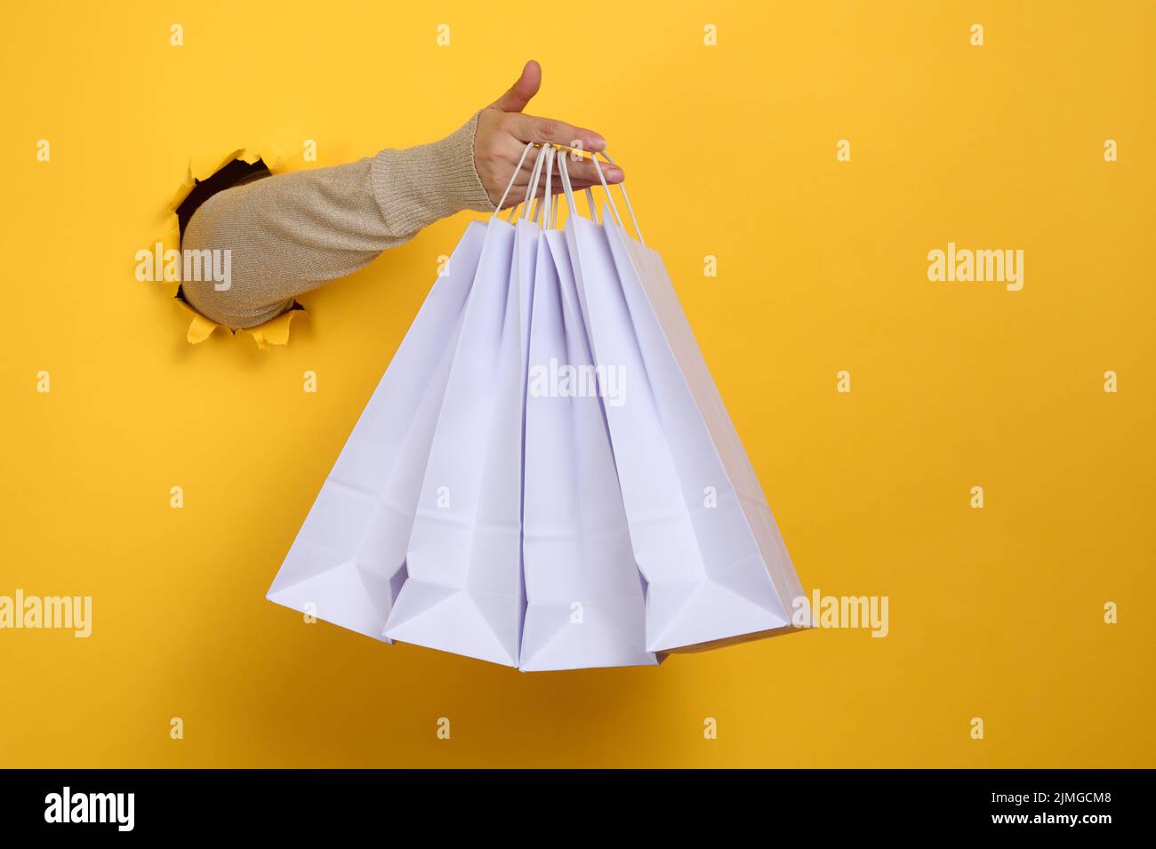 Female hand holds a white paper disposable bag with handles for ...