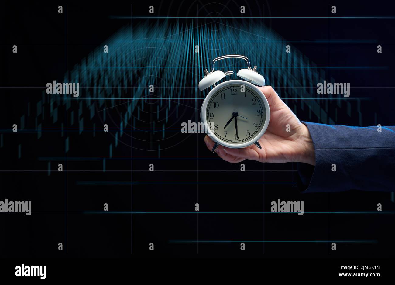 Hand of a businessman holds a round alarm clock on the background of charts. The concept of time is money. Stock Photo