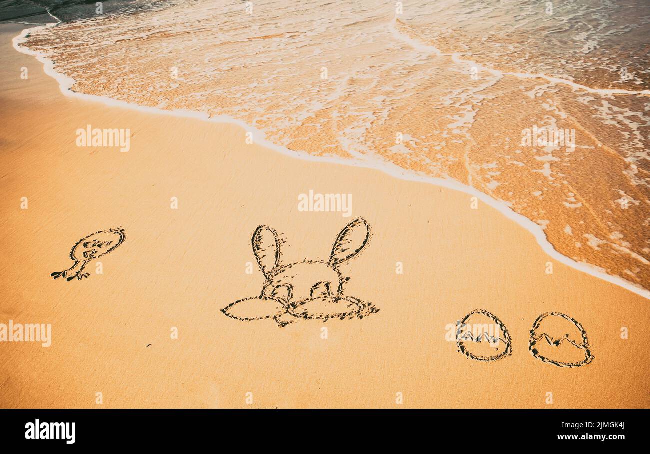 Easter bunny and eggs drawn in sand exotic Easter Stock Photo - Alamy