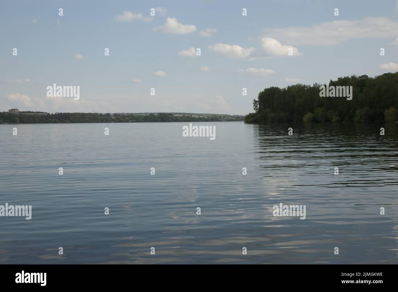 The blue sky with white clouds is reflected in the water with fine ...