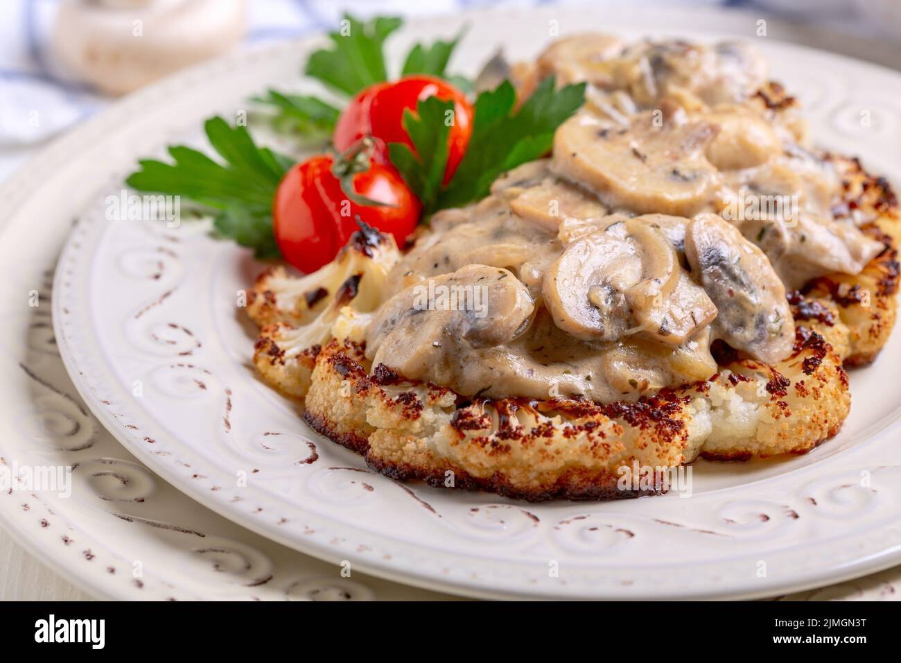 Cauliflower steak with mushrooms. Vegetarian cuisine. Stock Photo