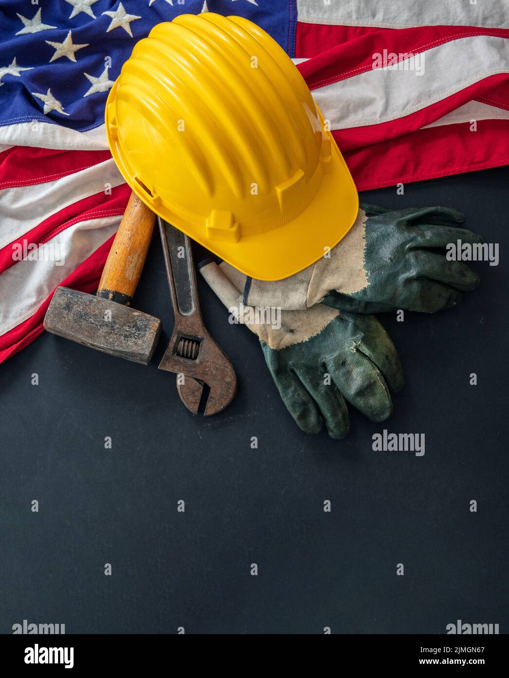 Labor Day concept. American flag and construction tools on dark background, above view. USA holiday celebration Stock Photo