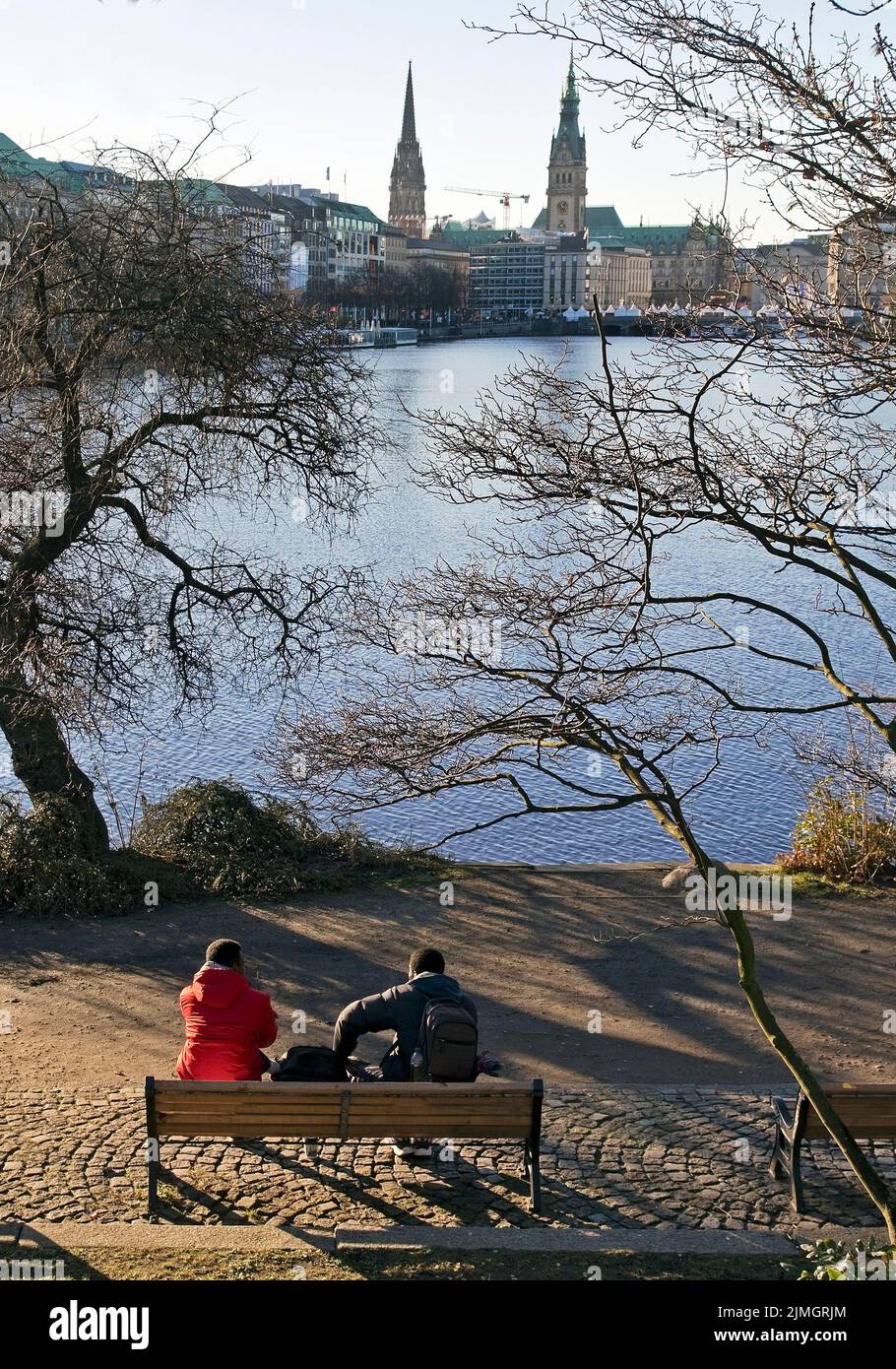People on a park bench by the Binnenalster with a view of the city skyline, Hamburg, Germany, Europe Stock Photo