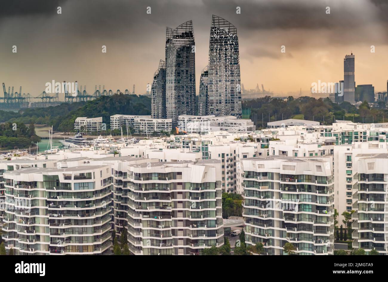Top of real estate housing in down town of Singapore, few skyscrapers on background, storm sky at sunset Stock Photo