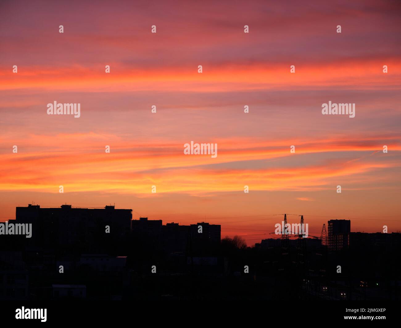 Bright sunset sky over the silhouette of the evening city. Beautiful bright sunset sky over building silhouettes Stock Photo