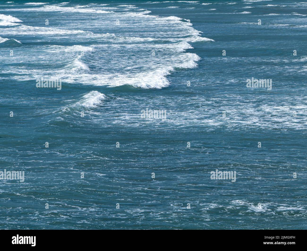 Beautiful white foam on turquoise tidal waves. The surface of the water as a background. Blue ocean water Stock Photo