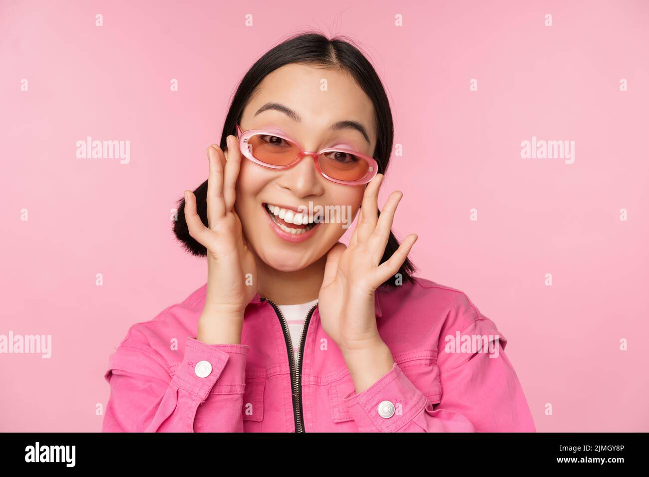 Cute modern japanese girl in sunglasses, smiling and looking happy