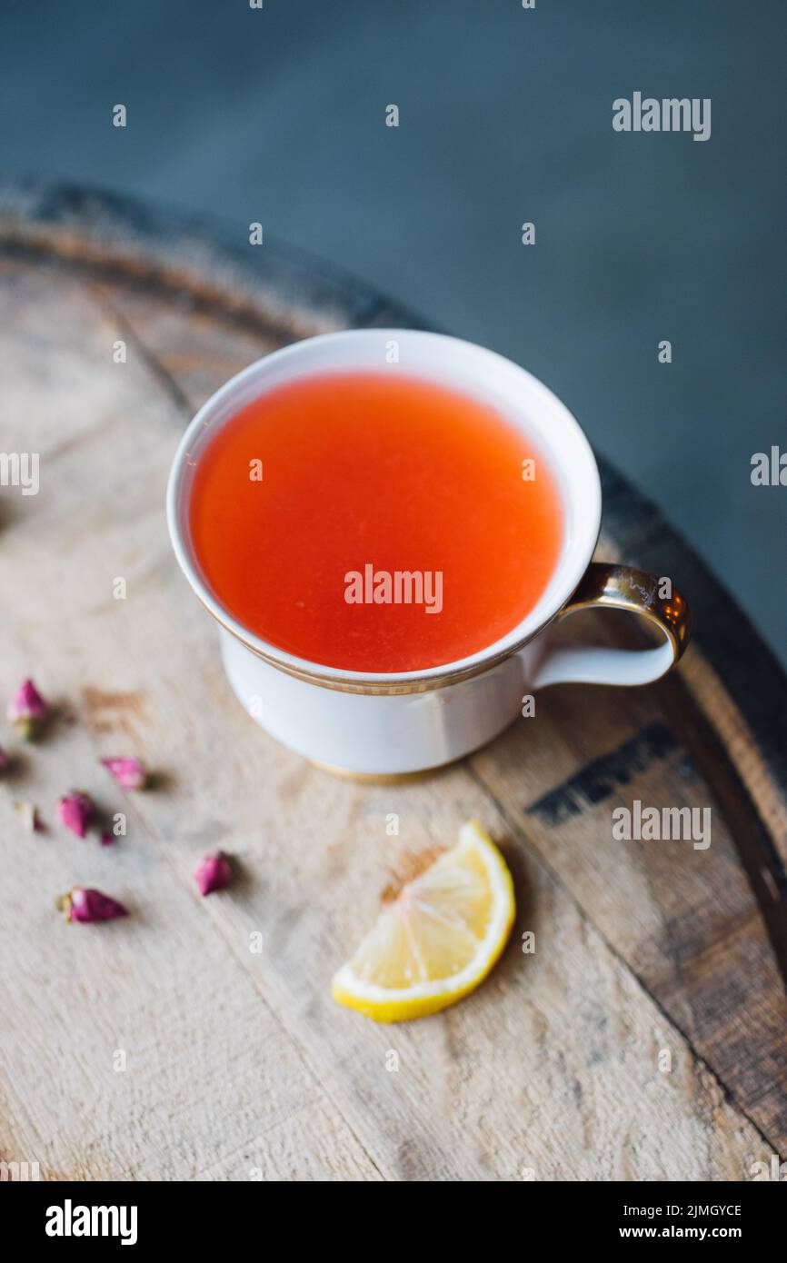 rooibos tea in cute cup on wood barrel with rosebuds and lemon Stock ...