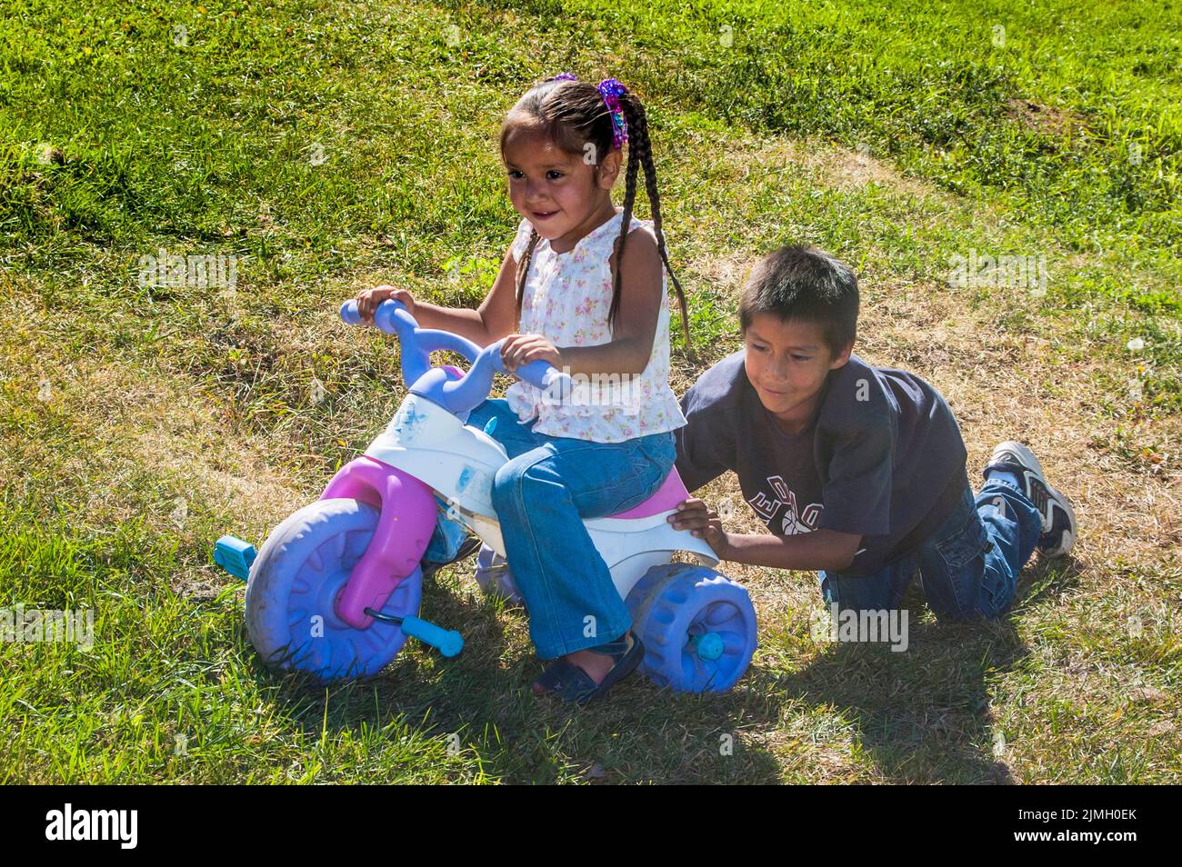 Older brother teaches his little sister how to ride her bike, Fort Hall, Idaho Stock Photo