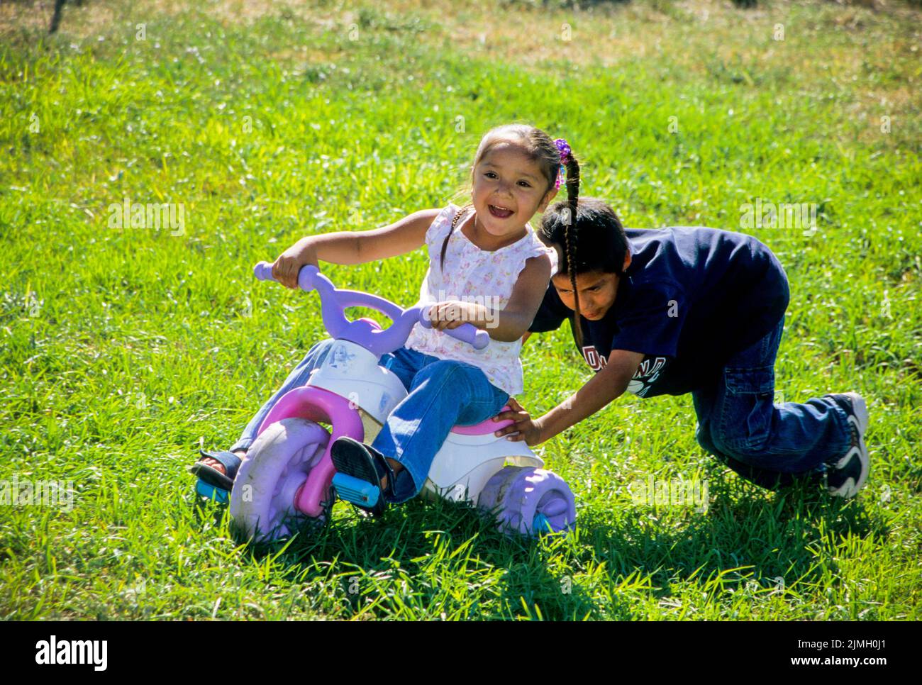 by pushing a toy scooter up hill on the Shoshone Bannock Indian Reservation, Fort Hall Idaho Stock Photo