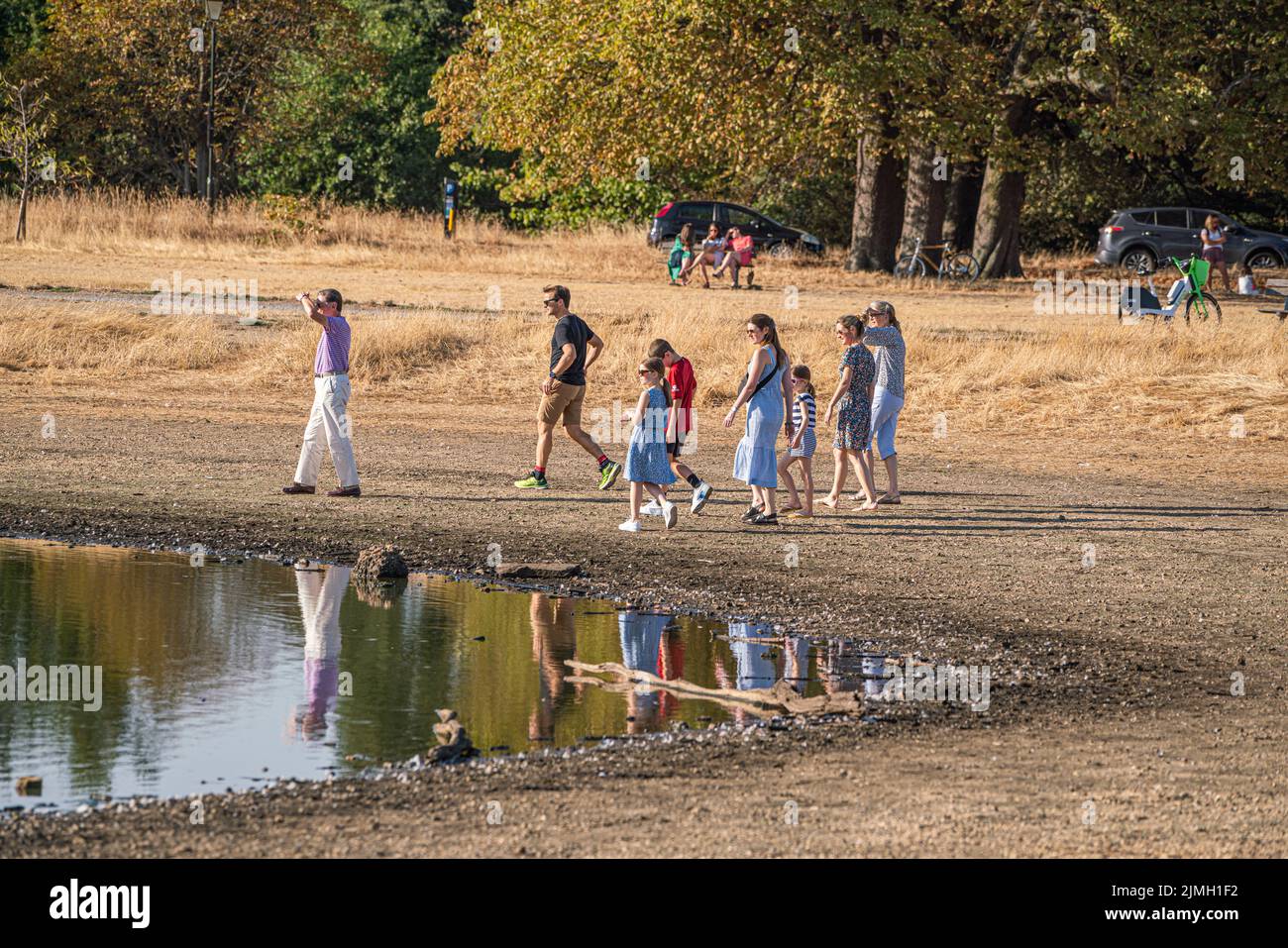 Wimbledon, London, UK. 6 August 2022  People walking  in the afternoon sunshine on the parched  grass of Wimbledon Common  as the hot weather and a lack of rainfall continue to grip much of the south of England and the UK, with temperatures expected to reach  above 30celsius  by next week Credit. amer ghazzal/Alamy Live News Stock Photo
