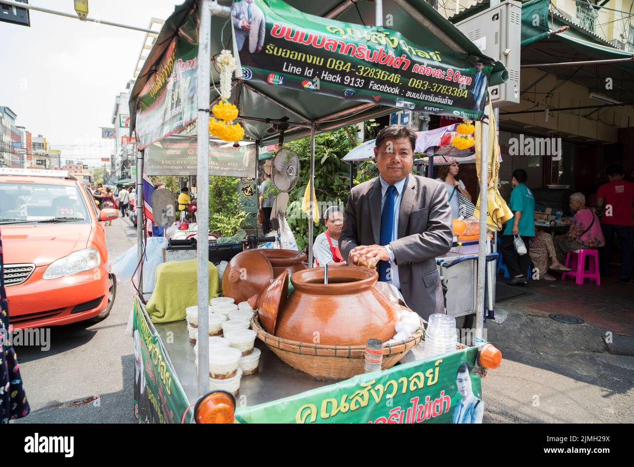 Bangkok city streets. Traditional Street seller and colorful taxis for transportation Stock Photo