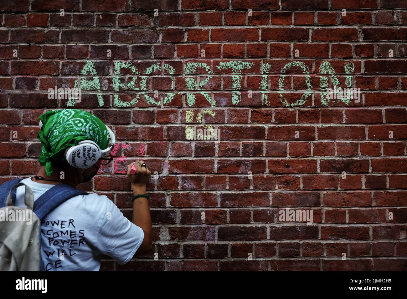 An abortion rights activist writes with chalk on a wall outside of St. Patrick's Old Cathedral in New York City,  U.S., August 6, 2022. REUTERS/Shannon Stapleton Stock Photo